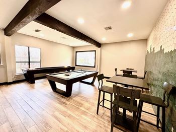 A room with a pool table and a dining table.